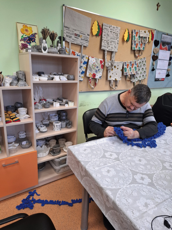 Verstaminuose įsikūrusių socialinių dirbtuvių lankytojai savo darbo vietose ir jų sukurti gaminiai, kuriuos nusipirkti galima užsukus tiesiai pas gamintojus.